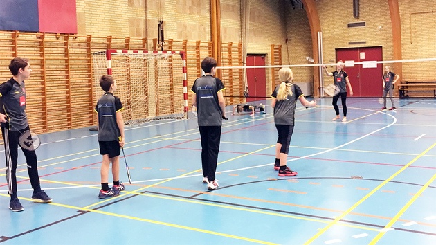 Børn varmer op til badminton med rundt-om-nettet